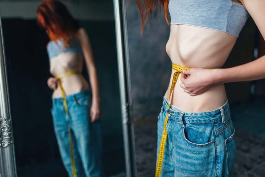 anorexic woman-measures-waist-